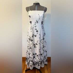 White dress with black velvet floral pattern with zipper back. Size 14